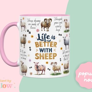 May include: White ceramic mug with a pink handle. The mug features a design of sheep and the text "Life is Better With Sheep".