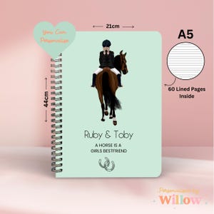 May include: A5 spiral-bound notebook with a light green cover. It features an illustration of a person riding a brown horse. The notebook is 44cm tall and 21cm wide, with 60 lined pages. Text includes "Ruby & Toby" and "A Horse Is A Girls Bestfriend."