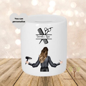 May include: White ceramic money box with a black and white illustration of a hairdresser holding scissors and a hairdryer. The text "Sarah's Tips" is printed on the box.