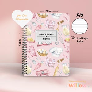 May include: A5 spiral-bound notebook with a pink cover featuring baking-themed illustrations. The notebook measures 44cm tall and 21cm wide, with 60 lined pages. The cover includes the text "Grace Evans Notes" and "You Can Personalise".