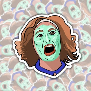 May include: A sticker featuring a cartoon illustration of a woman with brown hair wearing a blue shirt and a green face mask. The woman has a surprised expression on her face.