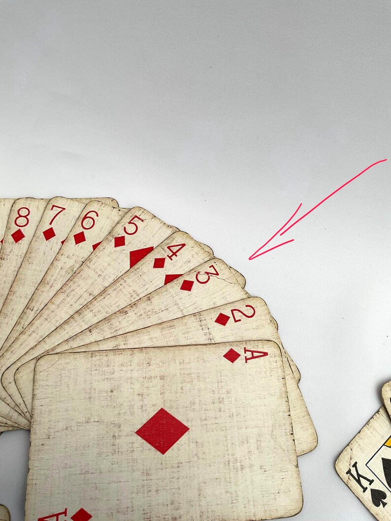 May include: A fan of antique playing cards featuring the suit of diamonds. The cards have a distressed, vintage look with red diamond symbols and numbers. The Ace, 2, 3, 4, 5, 6, 7, and 8 of diamonds are visible.