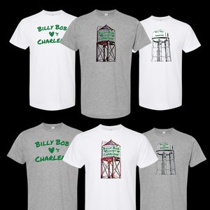 May include: Six t-shirts in various colors, including white and gray, with different designs featuring the text "Billy Bob loves Charlene" and a water tower graphic. The text is in green.