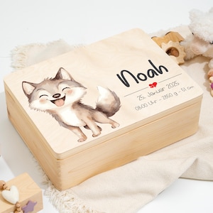 Peut inclure: Un coffret souvenir en bois clair avec une illustration de loup de dessin animé. La boîte est personnalisée avec le nom "Noah", la date de naissance, l'heure, le poids (2850 g) et la taille (51 cm). La boîte est rectangulaire avec un couvercle à charnière.