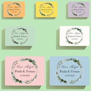 Puede incluir: Seis tarjetas de diferentes colores con una corona de hojas verdes y el texto "Unsere Hochzeit Paula & Tomas 12.08.2021" en negro.