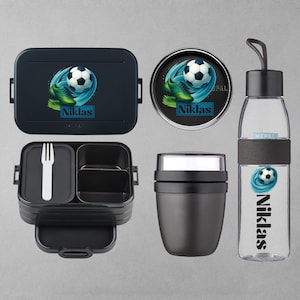 Könnte beinhalten: Ein Set aus schwarzen Lunchboxen und einer Trinkflasche. Jeder Artikel zeigt ein Fußball-Design mit dem Namen "Niklas". Das Set beinhaltet eine rechteckige Lunchbox, einen runden Behälter, eine Mehrkammer-Lunchbox mit Gabel, eine Thermoskanne und eine Trinkflasche.