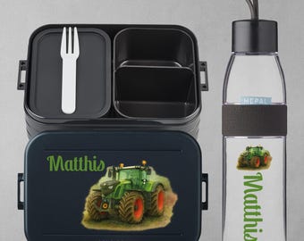 May include: A black and navy blue lunchbox and water bottle set. The lunchbox features a green tractor graphic and the name "Matthis" in green. The water bottle has a black cap and a matching tractor graphic.