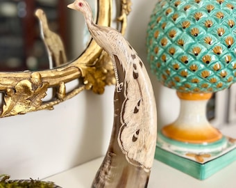 Estatua antigua de pavo real con cuerno tallado