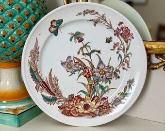 Plato de loza con decoración de motivos florales y fauna, coloreado a mano, de estilo antiguo.