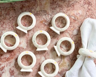 Juego de 8 servilleteros de cerámica vintage con estampado floral en crema, rosa y verde.