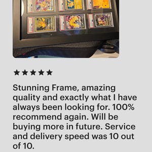 Puede incluir: Un marco de exhibici&oacute;n negro que contiene m&uacute;ltiples tarjetas coleccionables calificadas. Las tarjetas presentan ilustraciones coloridas y est&aacute;n encerradas en protectores. El marco se muestra sobre una superficie oscura.