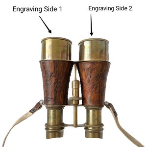 K&ouml;nnte beinhalten: Messing-Fernglas mit Holzmaserung und Lederriemen. Das Fernglas hat gravierte Details an den Seiten, beschriftet mit "Engraving Side 1" und "Engraving Side 2".