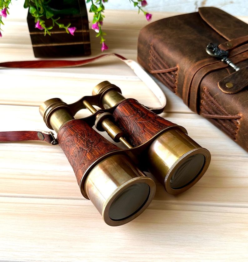 K&ouml;nnte beinhalten: Messing-Fernglas mit Holzmaserung und Lederriemen. Das Fernglas hat einen Vintage-Look und ist perfekt f&uuml;r die Vogelbeobachtung oder andere Outdoor-Aktivit&auml;ten.