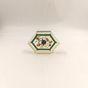 Peut inclure: Modèle de cellule hexagonal en plastique transparent avec une bordure verte, un noyau bleu, des organites jaunes et orange et de petits points noirs.