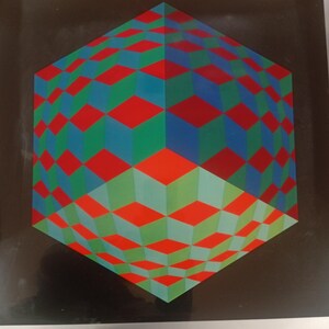 May include: A framed geometric art print featuring a three-dimensional cube design. The cube is composed of red, green, and blue diamond shapes, creating an optical illusion against a black background. The artwork is framed in a silver metal frame.