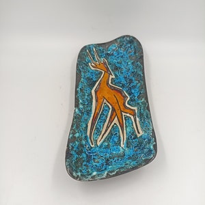 May include: A blue and orange ceramic dish with a stylized animal design. The dish is glazed with a textured finish.