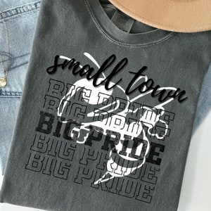 May include: A gray t-shirt with the text "small town" and a graphic of a bee with the text "BIG PRIDE" repeated in a stacked pattern.