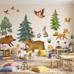 Könnte beinhalten: Ein Wandaufkleber-Set mit Aquarellillustrationen von Waldtieren, darunter ein Braunbär, ein Wildschwein, ein Fuchs, ein Hase, ein Eichhörnchen, eine Eule und Vögel, ergänzt durch grüne Kiefern, Pilze und kleine florale Akzente.