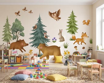 May include: A wall decal set featuring watercolor illustrations of forest animals including a brown bear, a wild boar, a fox, a rabbit, a squirrel, an owl, and birds, alongside green pine trees, mushrooms, and small floral accents.