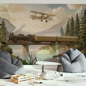 May include: A mural depicting a vintage train crossing a bridge, with a biplane flying overhead. The scene is set against a backdrop of mountains, trees, and a lake. Two gray beanbag chairs and a small table are in the foreground.