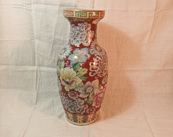 多色の花飾りと金色の仮面があしらわれたアジアの七宝焼きの大型花瓶