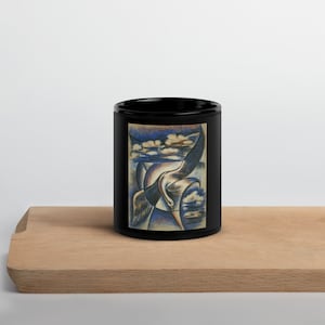 Könnte beinhalten: Schwarze Keramiktasse mit einem weißen Vogel im Flug vor einem blau-weißen Himmel. Der Vogel ist stilisiert und abstrakt, mit einem langen Hals und Flügeln. Der Himmel ist mit Wolken gefüllt.