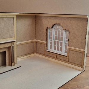 May include: A miniature dollhouse room with a fireplace, a window with an arched top, and wood paneling on the walls.