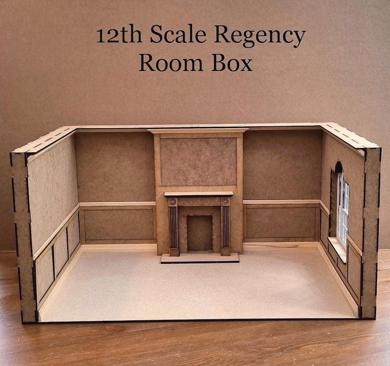 May include: A 12th scale Regency Room Box made of wood. The room box features a fireplace with a mantel and a window. The walls are painted a light brown color.