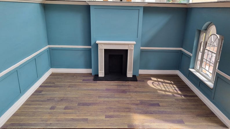 May include: A white fireplace with a black hearth in a room with blue walls and wood floors.