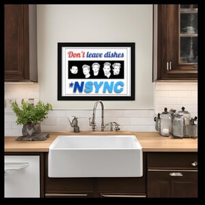 May include: A framed print with a black background and white text that reads "Don't leave dishes *NSYNC". The text is in red and blue. Five black and white images of men are in the center of the print. The print is hanging on a white tiled wall above a white kitchen sink.
