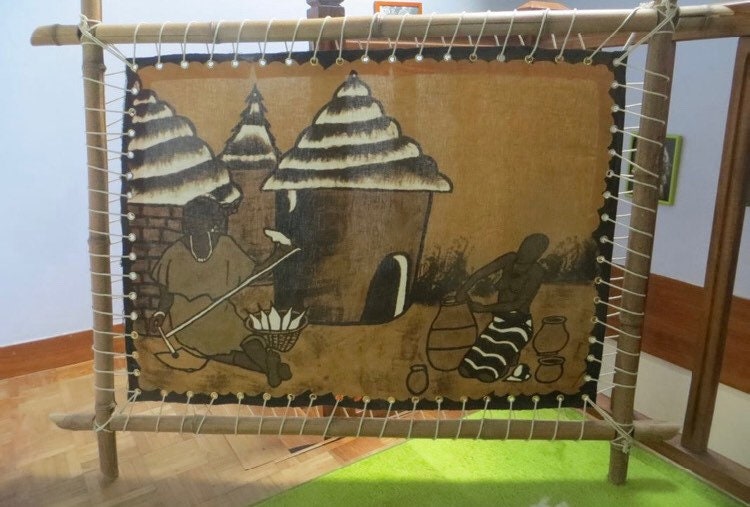 Toile en Bogolan [La Vie Au Village] sur Cadre Bambou 140 cm X 103cm.