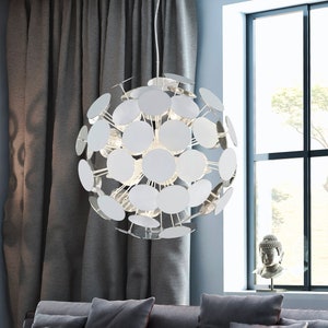 Puede incluir: Una lámpara colgante moderna de cromo y blanco con un diseño esférico. La lámpara está compuesta por múltiples discos circulares que están dispuestos en un patrón radial. La lámpara está colgada del techo en un salón.