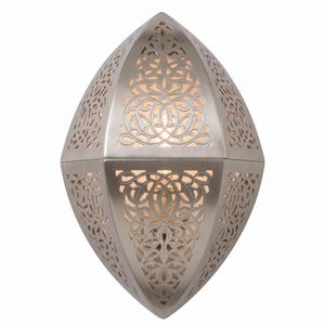 May include: A brushed nickel wall sconce with an elongated, pointed oval shape. The metal fixture features intricate, laser-cut filigree patterns that allow warm light to glow from within, creating a decorative effect on the surface.