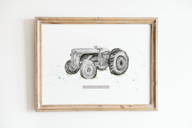 Puede incluir: Una pintura de acuarela enmarcada de un tractor gris con salpicaduras de pintura verde a su alrededor. El texto "Little Grey Ferrie" est&aacute; impreso debajo del tractor.