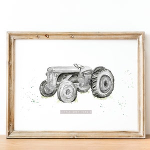 Puede incluir: Una ilustraci&oacute;n de acuarela en blanco y negro de un tractor vintage sobre un fondo blanco con salpicaduras de acuarela verde. El texto "Little Grey Ferdie" est&aacute; impreso debajo del tractor.