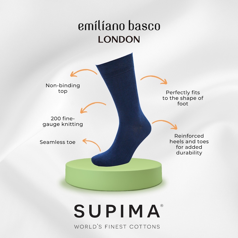 May include: A pair of dark blue socks made with Supima cotton. The socks feature a seamless toe, reinforced heels and toes, and a non-binding top. The socks are displayed on a green platform with the text "SUPIMA" and "WORLD'S FINEST COTTONS" below.