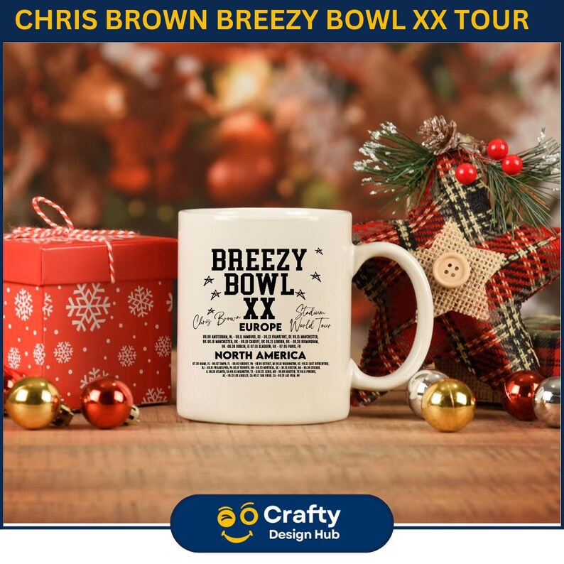 May include: A white ceramic mug with the text "BREEZY BOWL XX" and tour details. The mug is on a wooden surface with Christmas ornaments and a red gift box. The mug is part of the Chris Brown Breezy Bowl XX Tour.