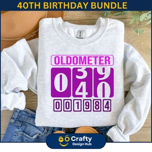 May include: A gray sweatshirt with a purple graphic that says "Oldometer" and displays the numbers "0340" and "001984".
