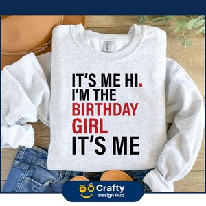 May include: Gray sweatshirt with the text "It's me hi. I'm the birthday girl. It's me" in black and red lettering.