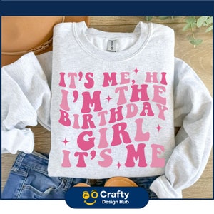 May include: A gray sweatshirt with pink lettering that reads "It's Me, Hi I'm The Birthday Girl It's Me".