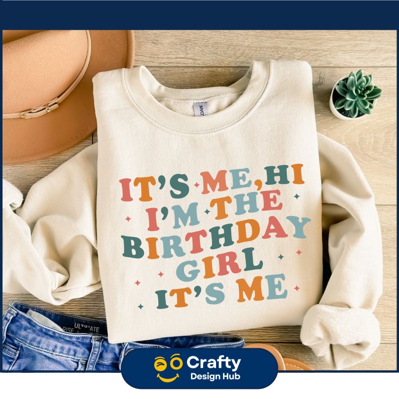 May include: A white sweatshirt with the text "IT'S ME, HI I'M THE BIRTHDAY GIRL IT'S ME" in colorful retro-style lettering.