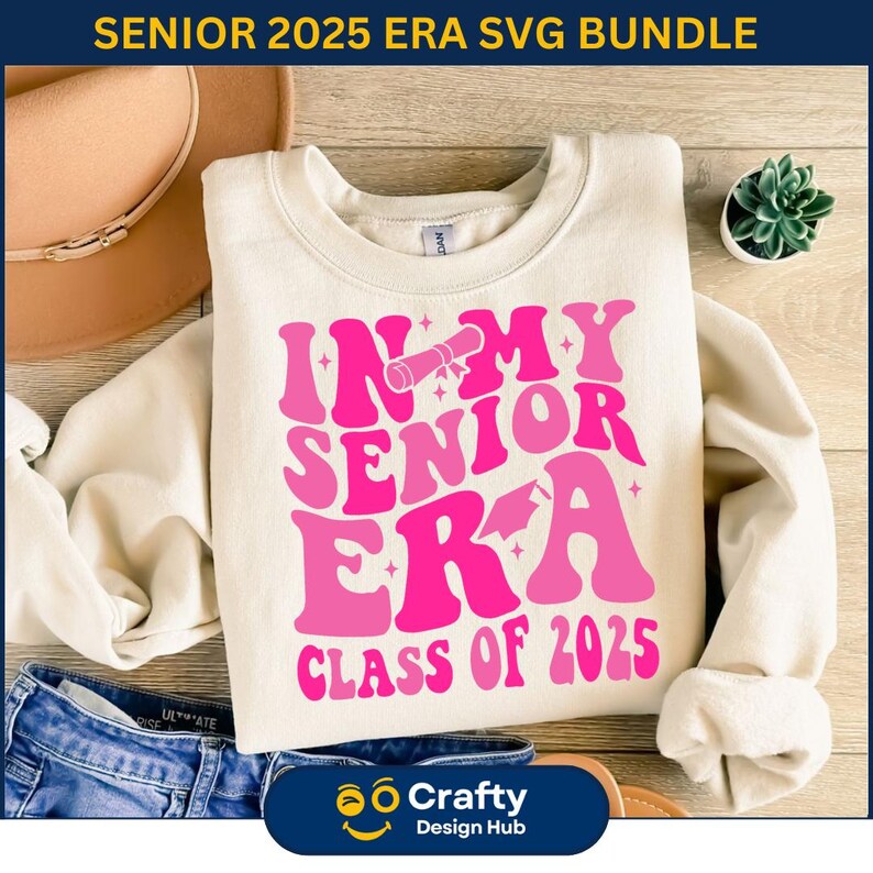 May include: A white sweatshirt with a pink graphic design that says "In My Senior Era Class of 2025".