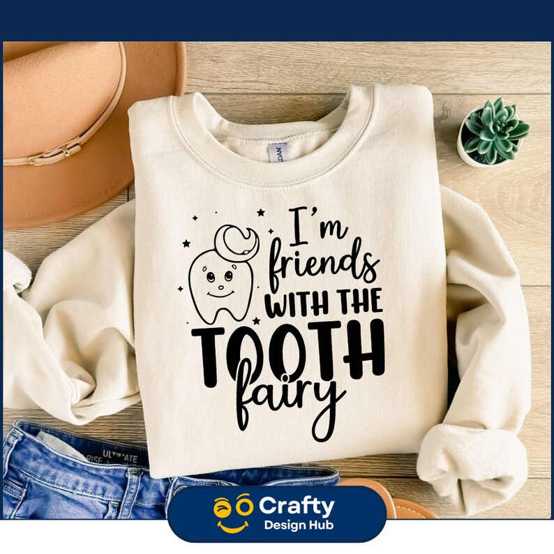 Pu&ograve; includere: Una felpa bianca con un design grafico nero che dice "Sono amico della fatina dei denti". La grafica include un dente di cartone animato con una luna e stelle.