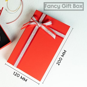 a red gift box with a bow and a pair of scissors