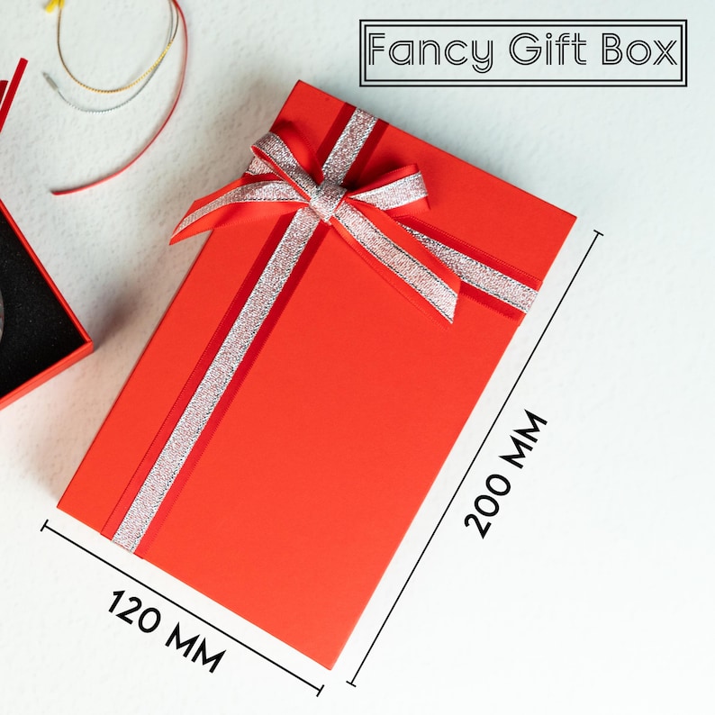 a red gift box with a bow and a pair of scissors