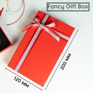 a red gift box with a bow and a pair of scissors
