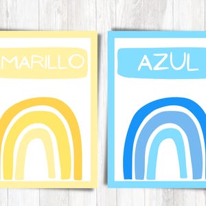 May include: Two printable cards with rainbow designs. The card on the left has a yellow rainbow and the text "AMARILLO". The card on the right has a blue rainbow and the text "AZUL".