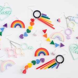 Pu&ograve; includere: Assortimento di orecchini a tema arcobaleno con archi arcobaleno, cuori e simboli di genere. Gli orecchini sono in acrilico e sono disponibili in una variet&agrave; di colori, tra cui rosa, blu, verde, giallo, arancione e rosso. Gli orecchini sono perfetti per aggiungere un tocco di fantasia e colore a qualsiasi outfit.