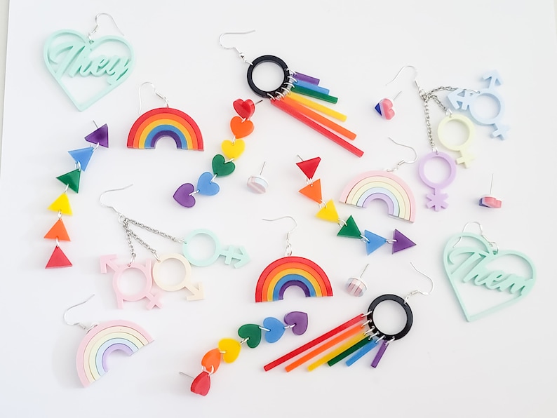 Pu&ograve; includere: Assortimento di orecchini a tema arcobaleno con archi arcobaleno, cuori e simboli di genere. Gli orecchini sono in acrilico e sono disponibili in una variet&agrave; di colori, tra cui rosa, blu, verde, giallo, arancione e rosso. Gli orecchini sono perfetti per aggiungere un tocco di fantasia e colore a qualsiasi outfit.
