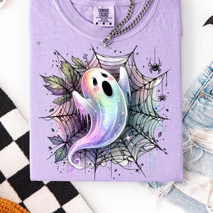 May include: A white ceramic mug with a black handle and the text "But First, Coffee" in a bold, black font. The mug is set against a blurred background, suggesting a cozy setting.